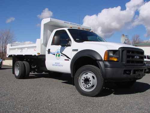 A white ford work truck with a public works logo o